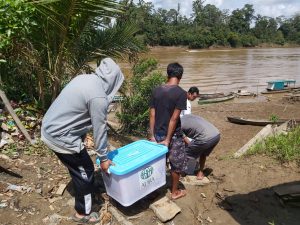 orang angkat bantuan di pinggir sungai